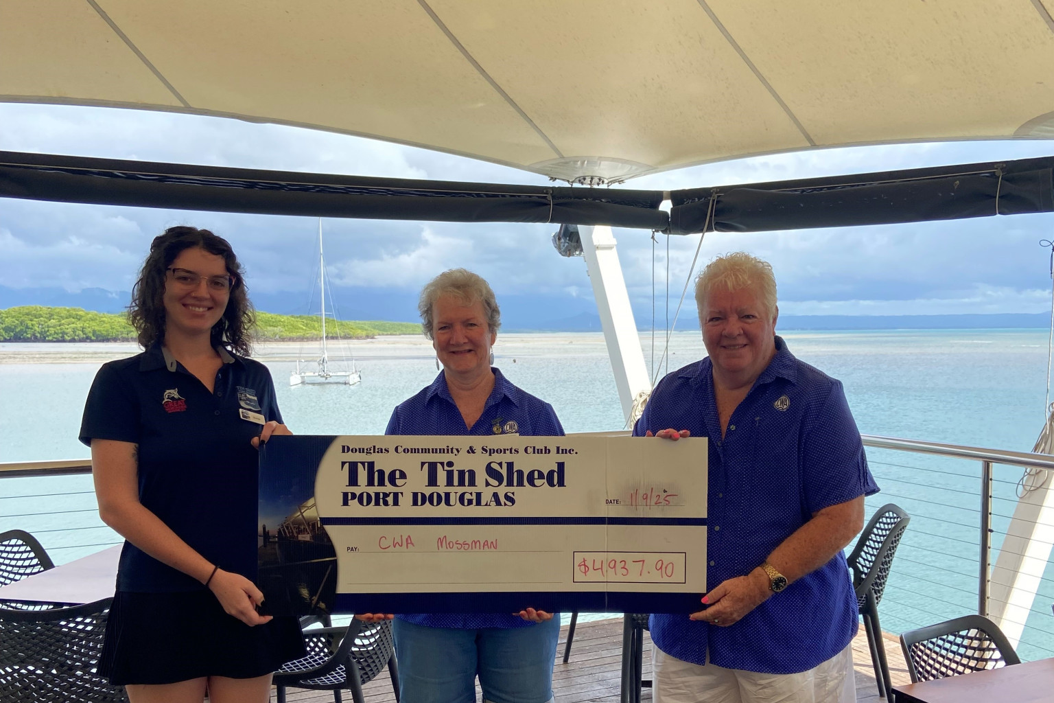 Tin Shed team member Bonnie (surname withheld) presents a cheque To Mossman QCWA members Valerie Geary and Carolyn Appleby. Picture: Supplied