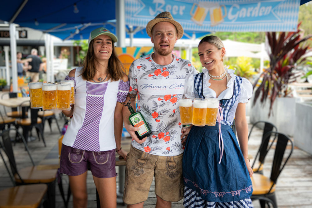 Giving traditional Oktoberfest dirndl and lederhosen garb a tropical spin are Heloise Dufief, Roman Haslinger and Jade Louis. Picture: Supplied