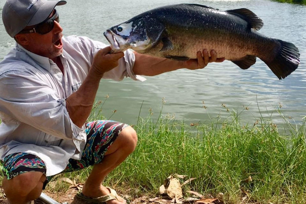 An angler marvels at his barra catch at Hookaburra Fishing. Picture: Supplied